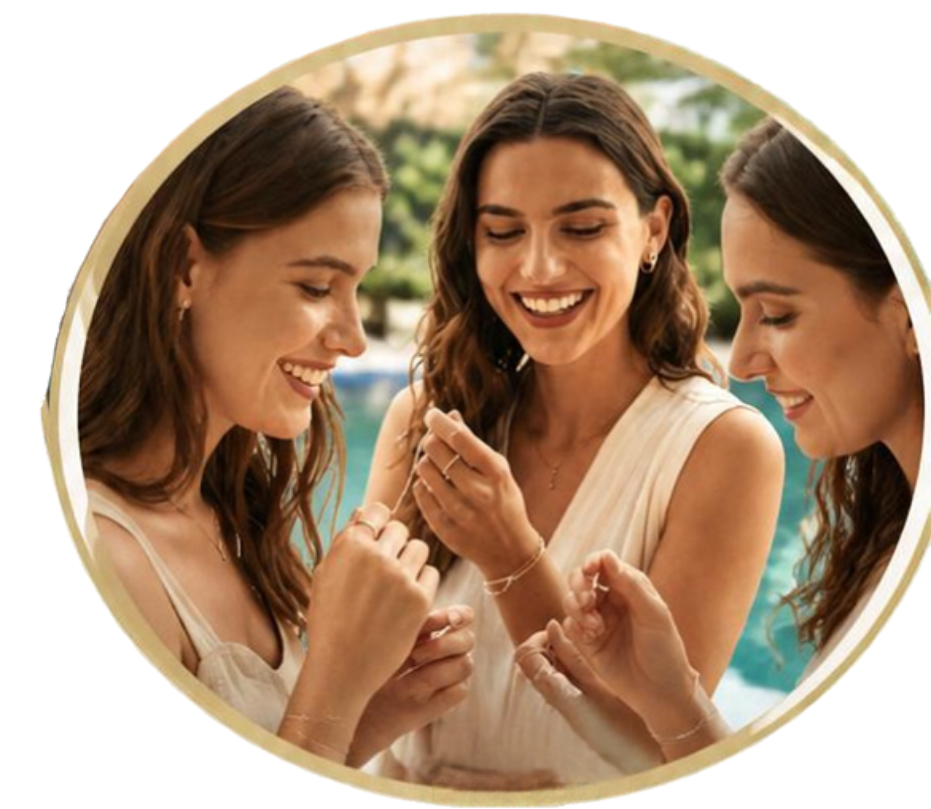 Permanent Jewelry Party Poster 1 - Steala LLC Fine Art Accessories Three women in white dresses by a pool smile as they try on delicate gold bracelets together by the water.